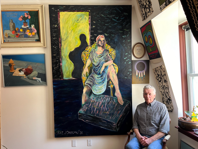 Herb sitting in front of an emotional work by Rae Johnson, a painting titled “Madonna at the Moment of Immaculate Conception” with paintings by Derek Caines (lower left) and J. Mac Reynolds (upper left).