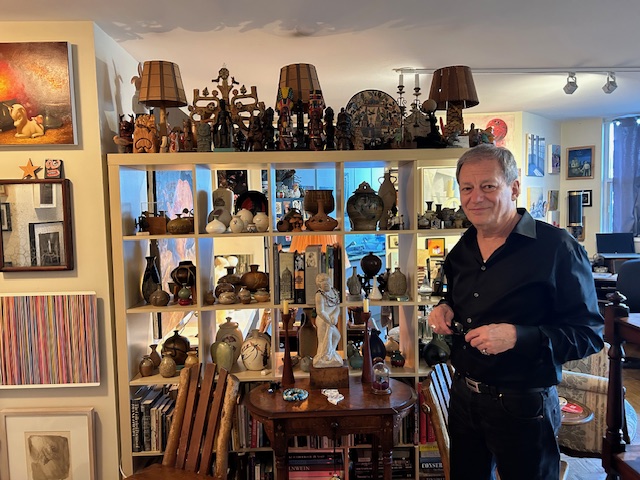 Flavio standing next to his collection of artifacts acquired over the years