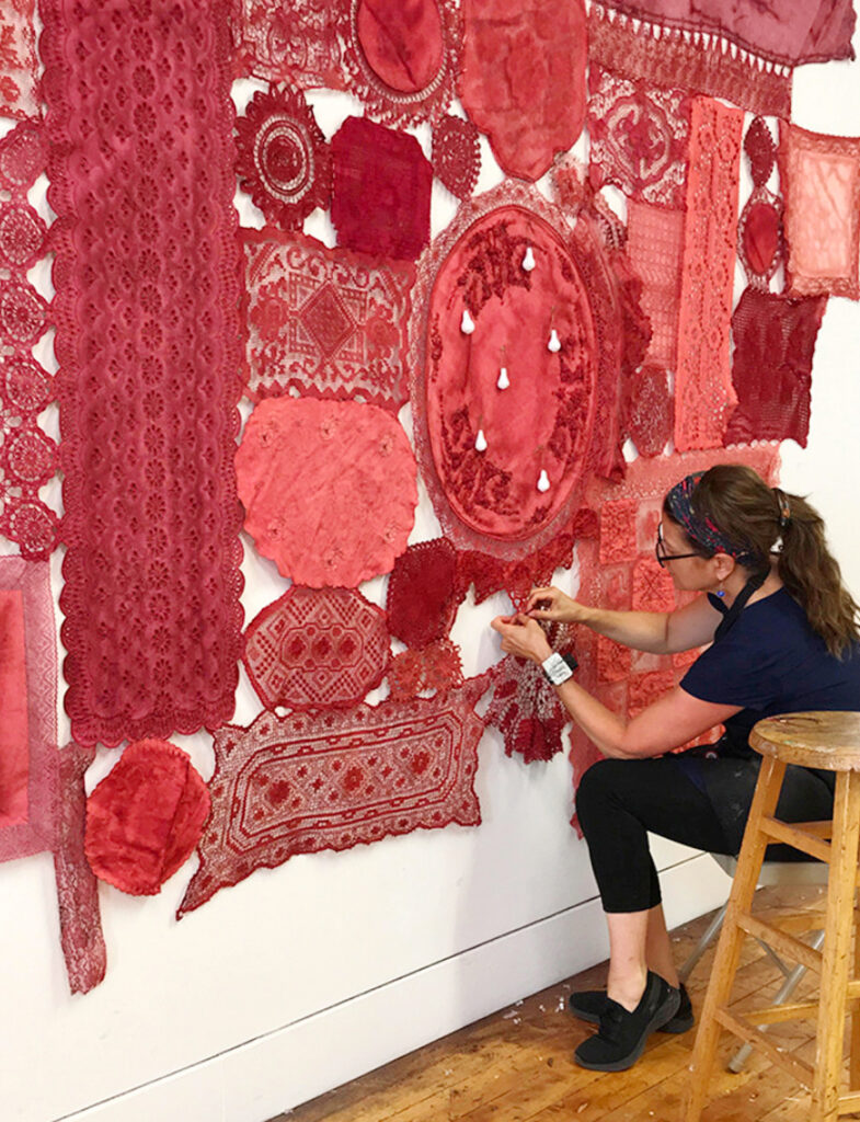Patricia Miranda installing Lamentation for a Reasoned History, 2023, donated hand-dyed lace, thread, dressmaker pins, paper clay, cast plaster; dimensions to fit the space